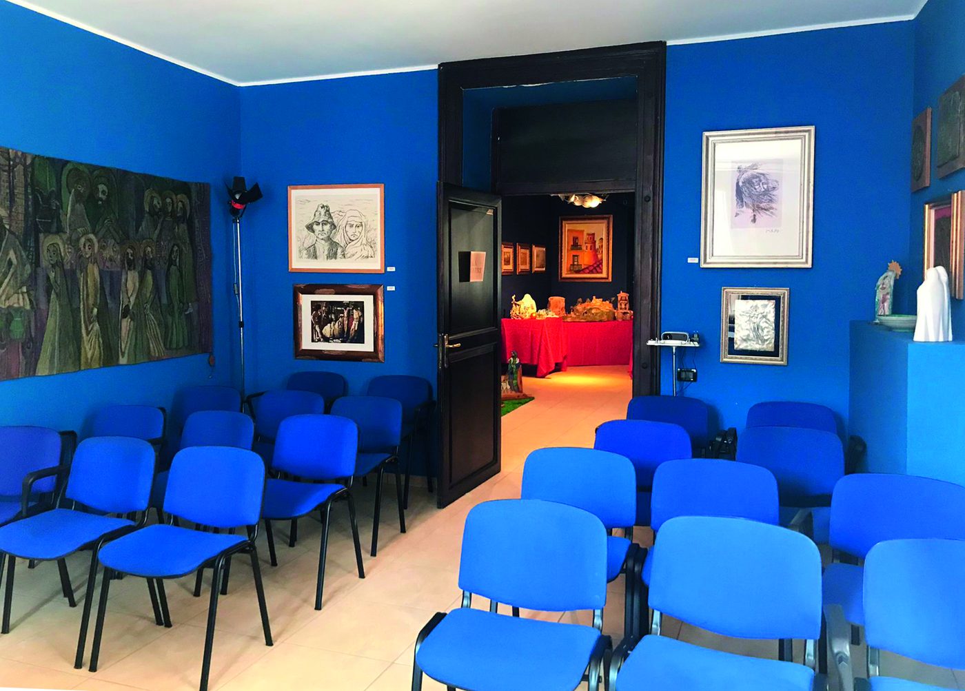 La meeting room con le sedute blu e la quadreria
